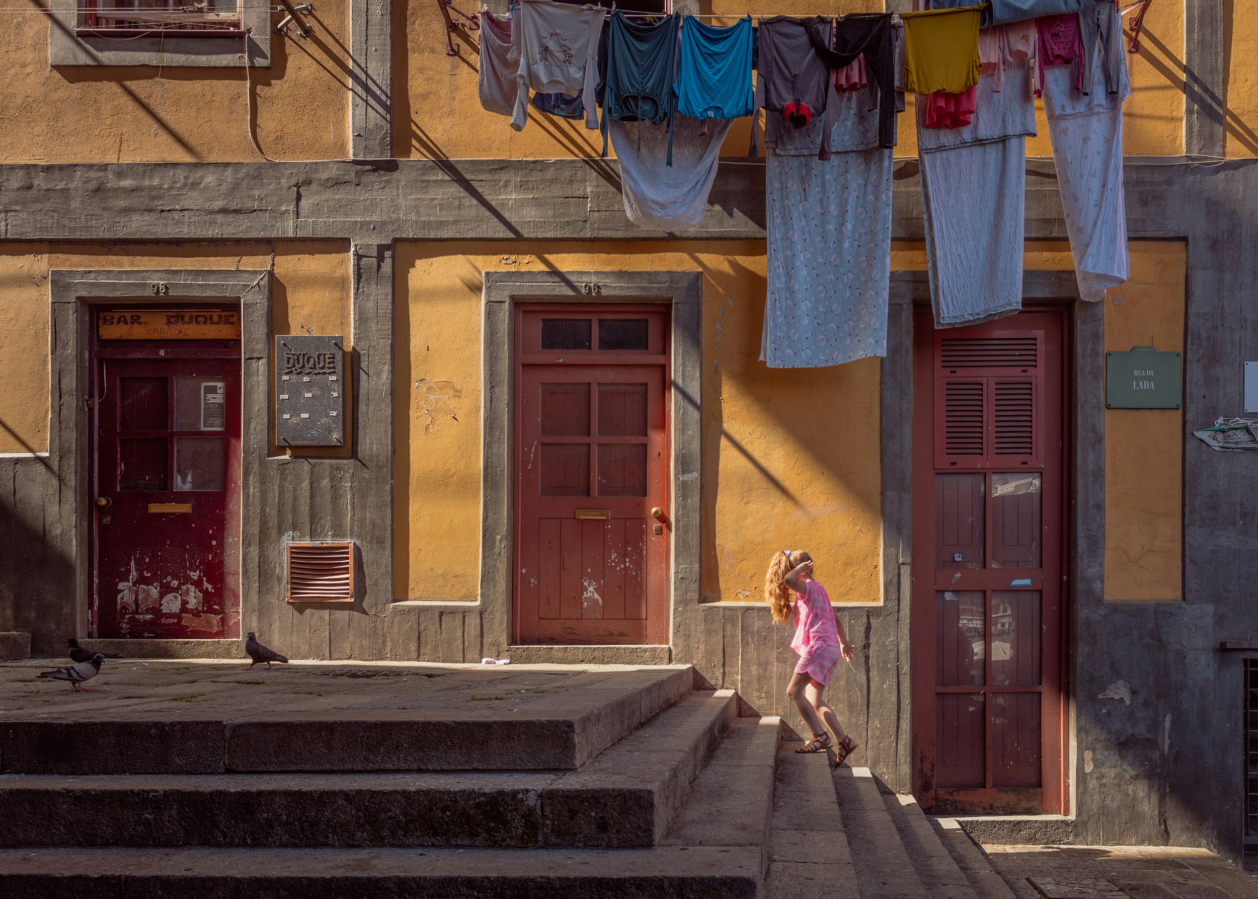 person walking on stairs beside brown door house